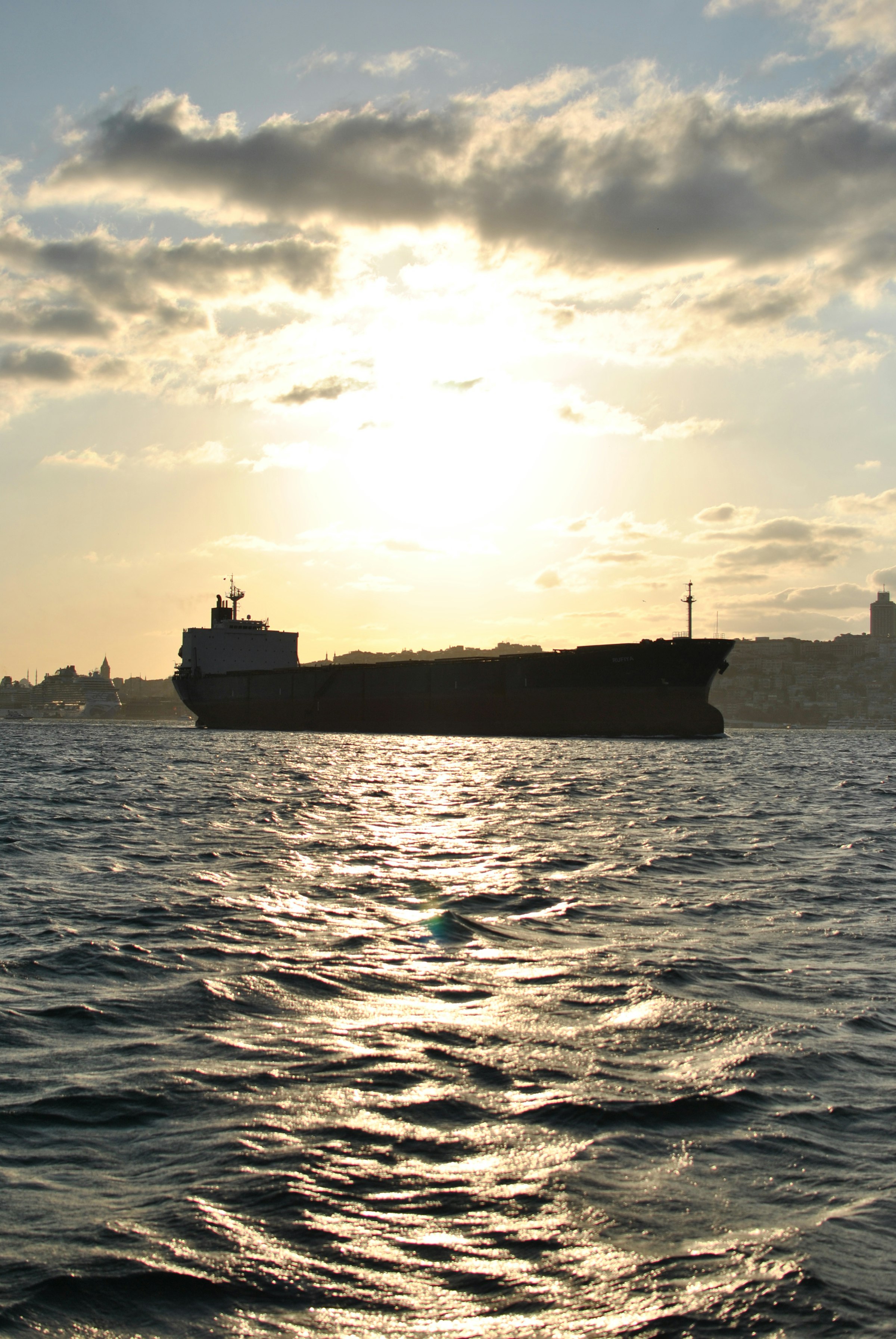 Cargo ship crossing the ocean at sunset